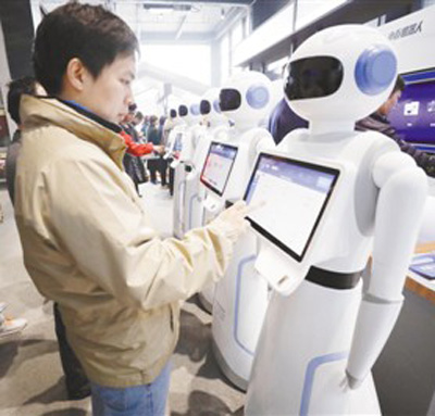 2017年12月4日，在浙江乌镇举行的第四届世界互联网大会“互联网之光”博览会上，民众体验人工智能机器人。人民视觉